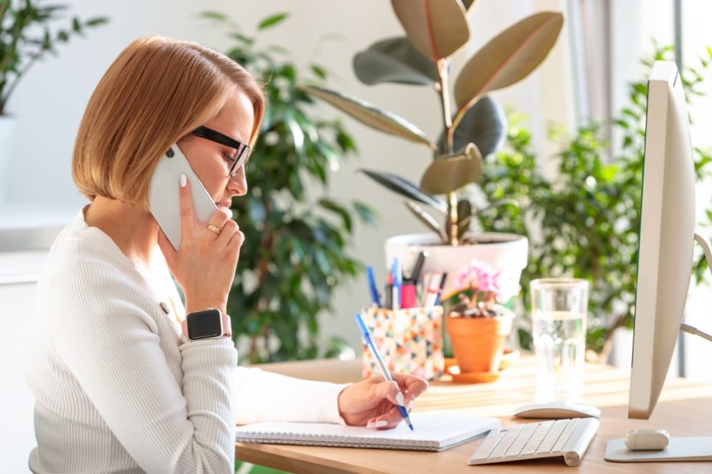 os direitos da mulher - mulher falando ao telefone durante o trabalho